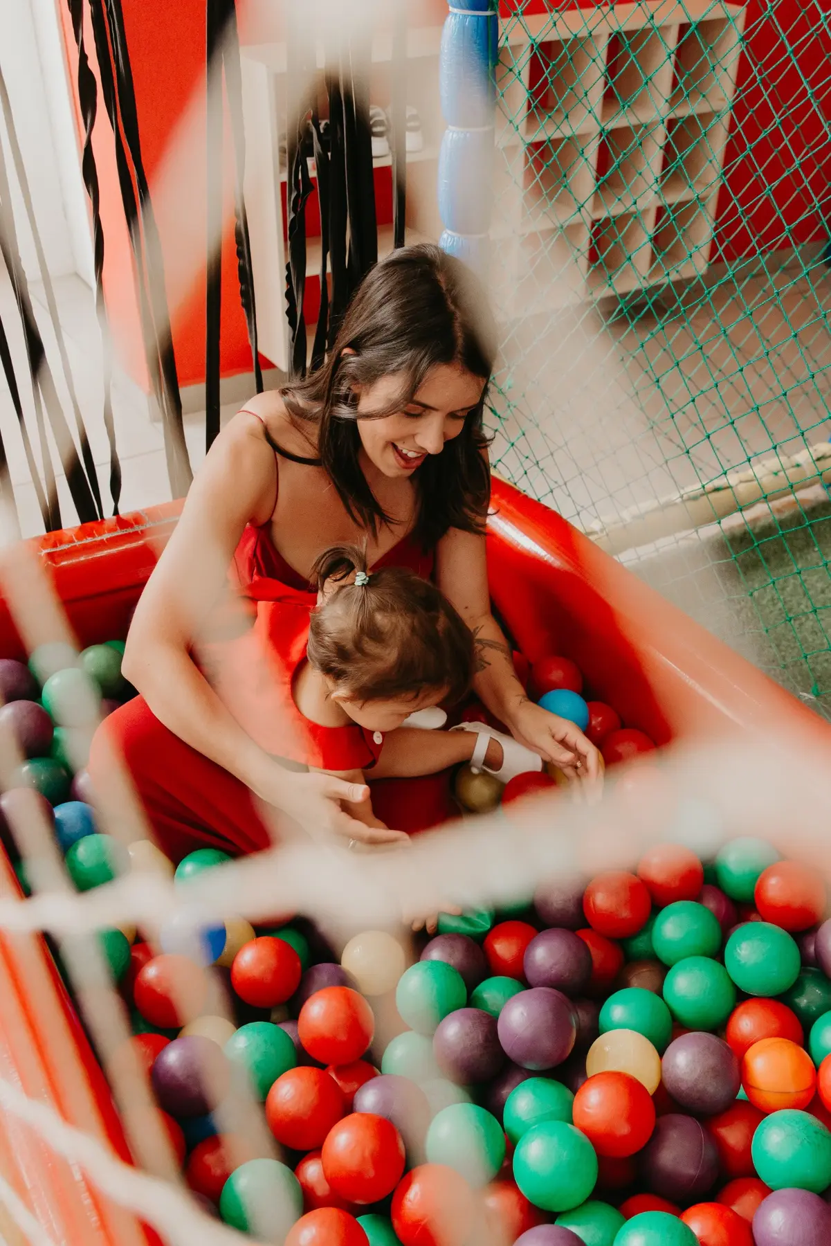 Mãe e criança brincando em piscina de bolinhas