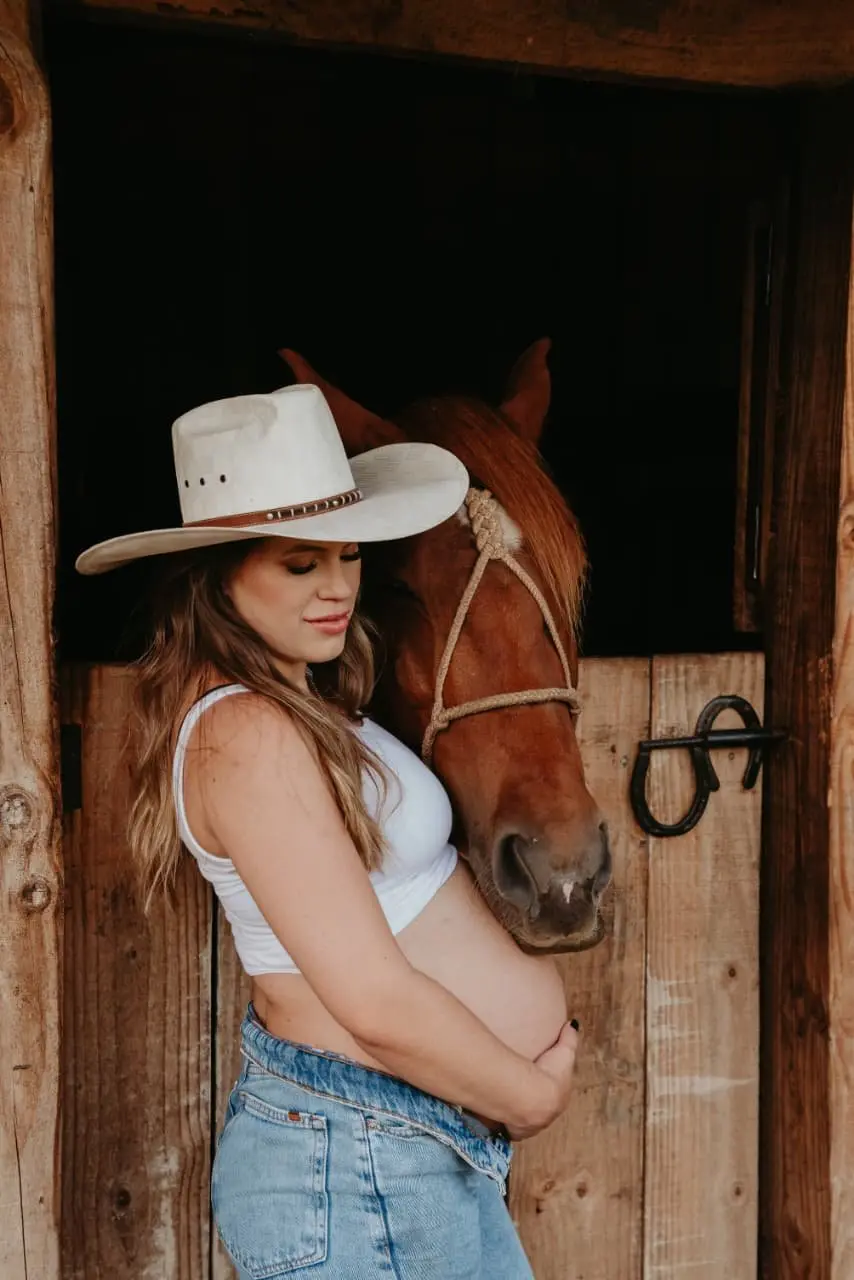 Gestante junto a um cavalo durante ensaio